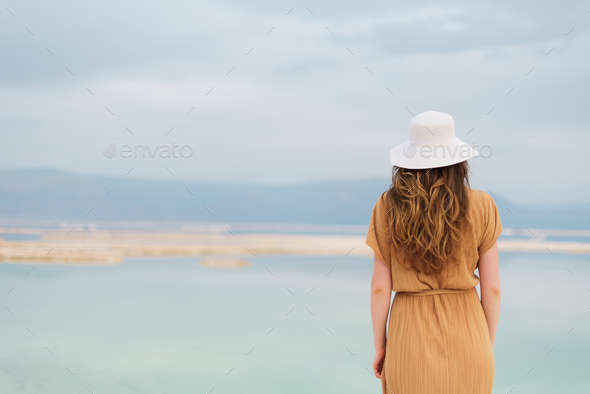 Young girl with shining blonde hair goes to seaside, Dead Sea beach. Banner. Travel, summer vacation - Stock Photo - Images