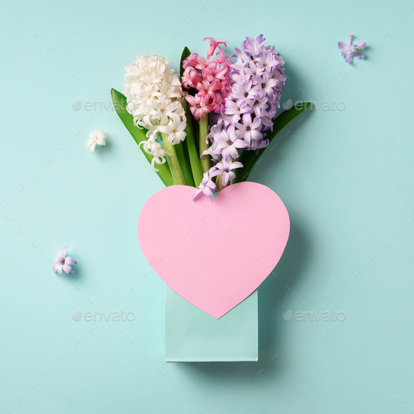 Spring hyacinth flowers in shopping bag, pink paper heart on blue punchy pastel background. Square - Stock Photo - Images