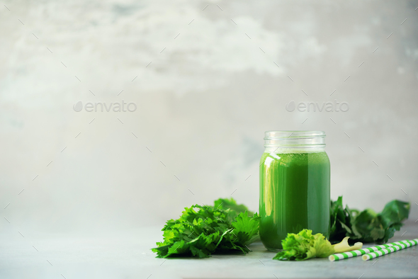 Bottle of green celery smoothie on grey concrete background. Banner with copy space. Square crop - Stock Photo - Images