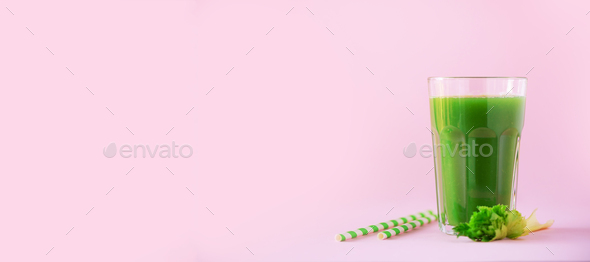 Glass of green celery smoothie on pink background. Banner with copy space. Fresh juice for detox - Stock Photo - Images