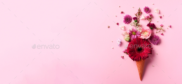 Summer minimal concept. Ice cream cone with pink flowers and leaves on punchy pastel background - Stock Photo - Images