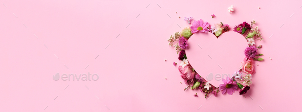 Creative layout with pink flowers, paper heart over punchy pastel background. Top view, flat lay - Stock Photo - Images