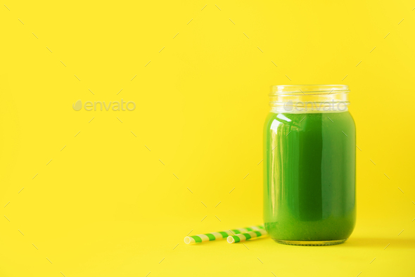 Bottle of green celery smoothie on yellow background. Banner with copy space. Fresh juice for detox - Stock Photo - Images