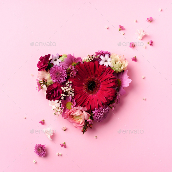 Heart shape made of spring flowers on pink punchy pastel background. Top view, flat lay. Summer - Stock Photo - Images