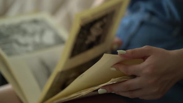 Woman Looking at Old Photo Album of Her Family