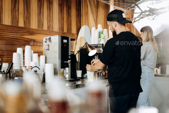 A young stylish man with beard,dressed i casual style,is cooking coffee in the expensive coffee - Stock Photo - Images
