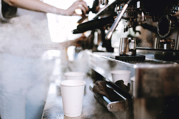 The process of cooking coffee is shown. Two glasses are standing next to a coffee machine, while - Stock Photo - Images