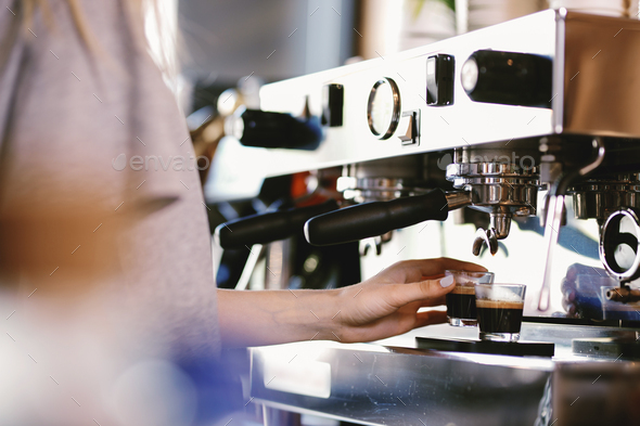 A young pretty blonde,wearing casual outfit,takes a cup of fresh coffee from an expensive coffee - Stock Photo - Images