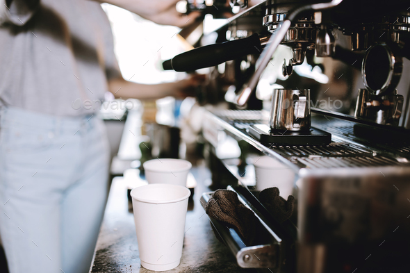 The process of cooking coffee is shown. Two glasses are standing next to a coffee machine, while - Stock Photo - Images