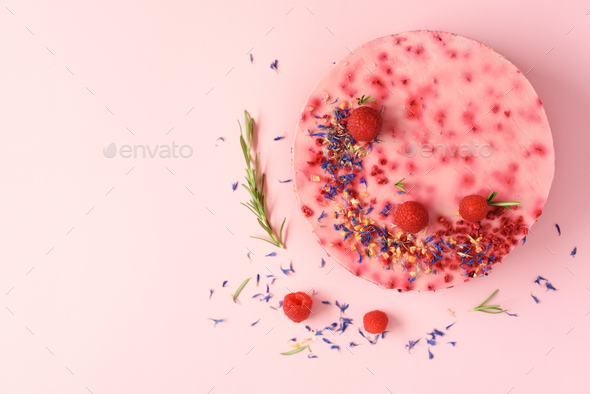 Delicious raspberry cake with fresh berries, rosemary and dry flowers on pink background. Copy space - Stock Photo - Images