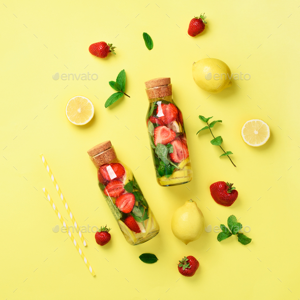 Bottle of detox water with mint, lemon, strawberry on yellow background. Square crop. Flat lay - Stock Photo - Images