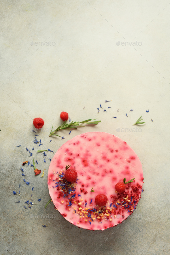 Delicious raspberry cake with fresh berries, rosemary and dry flowers on gray concrete background - Stock Photo - Images