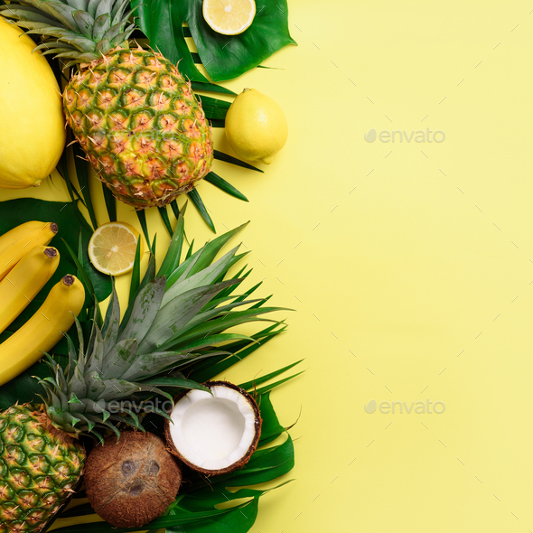 Exotic pineapples, coconuts, banana, melon, lemon, palm and monstera leaves on yellow, violet - Stock Photo - Images