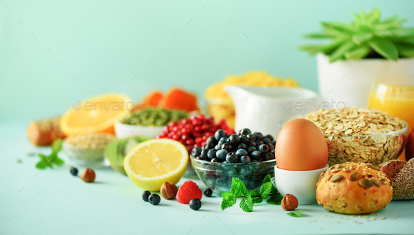 Healthy breakfast ingredients, food frame. Oat and corn flakes, eggs, nuts, fruits, berries, toast - Stock Photo - Images