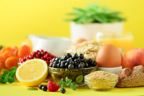 Breakfast served with soft boiled egg, oat flakes, nuts, fruits, berries, milk, yogurt, orange - Stock Photo - Images