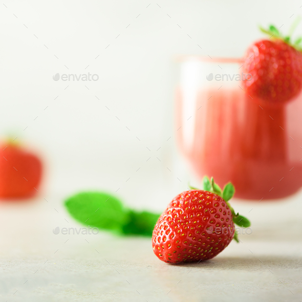 Glass with vegan strawberry smoothie on grey background with copy space. Square crop. Summer food - Stock Photo - Images
