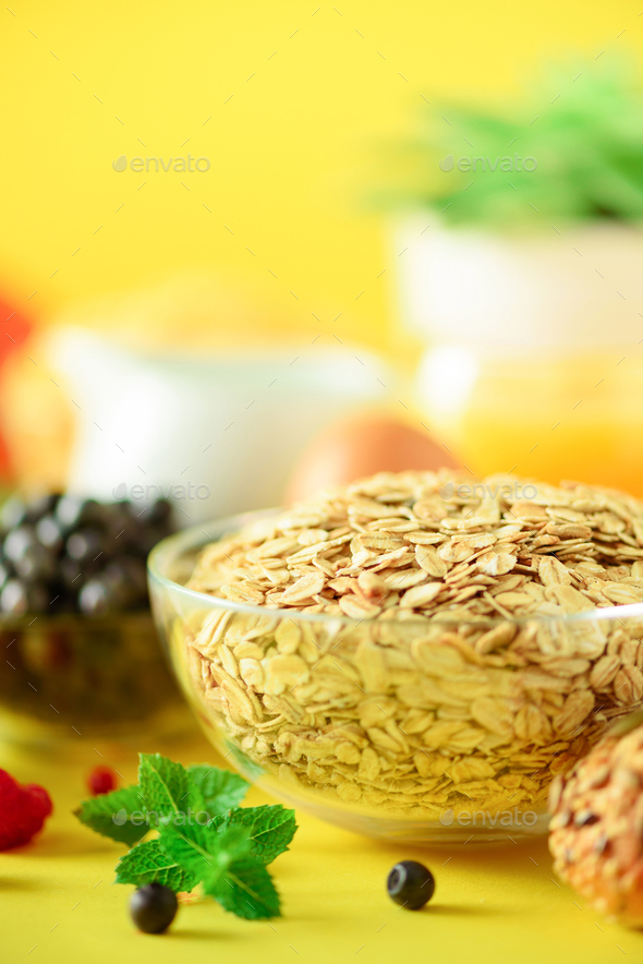 Oat flakes with milk, fresh berries, yogurt, boiled egg, nuts, fruits, orange, banana, peach for - Stock Photo - Images