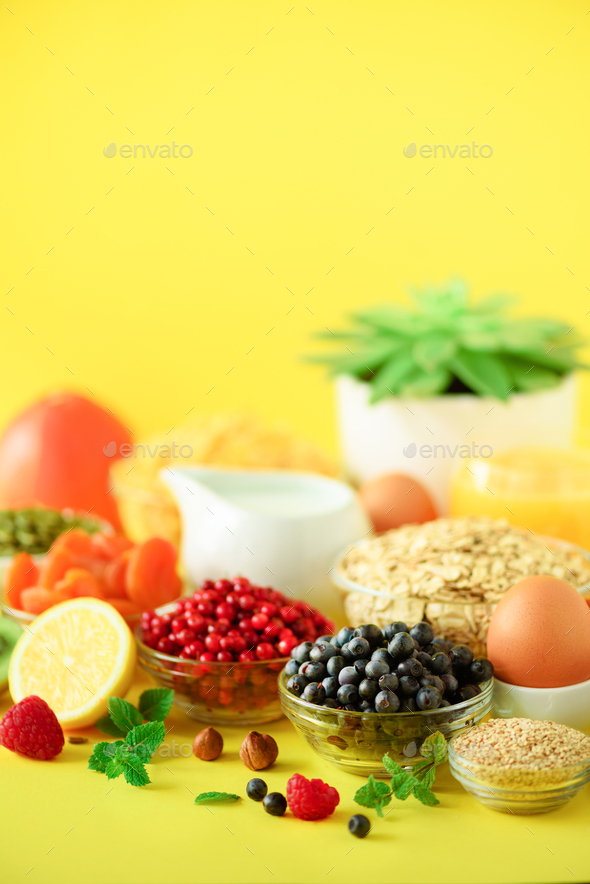 Vegan breakfast. Soft boiled egg, oat flakes, nuts, fruits, berries, milk, yogurt, orange, banana - Stock Photo - Images