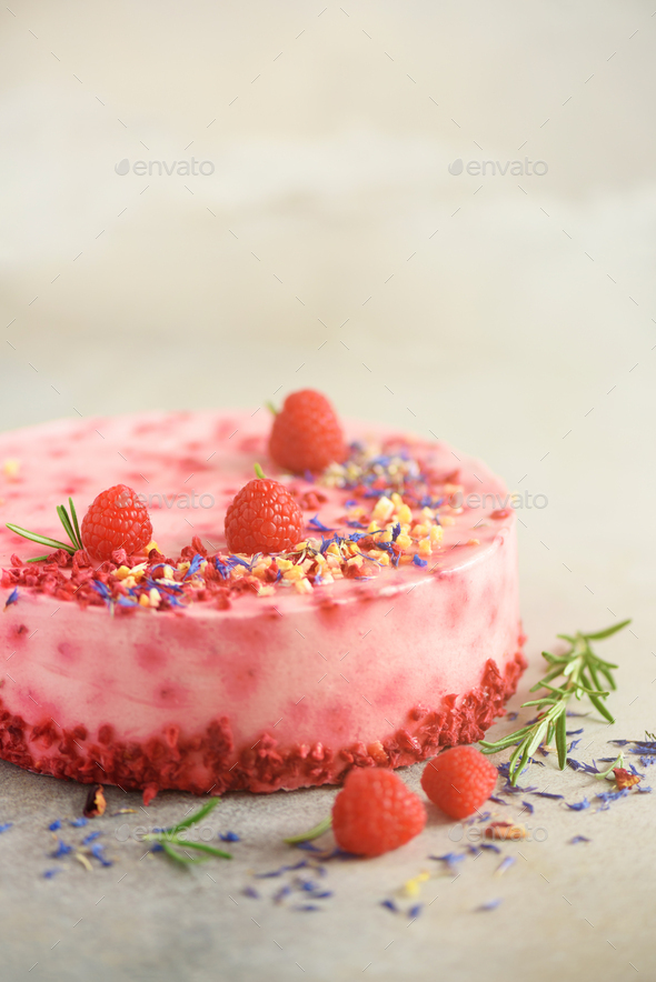 Delicious raspberry cake with fresh berries, rosemary and dry flowers on gray concrete background - Stock Photo - Images