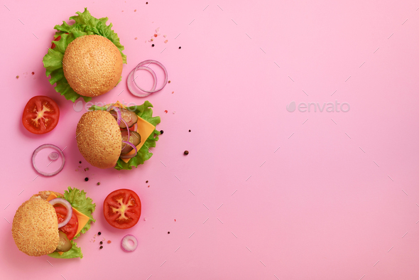 Delicious burgers, cheese, lettuce, onion, tomatoes on pink background. Close up banner. Unhealthy - Stock Photo - Images