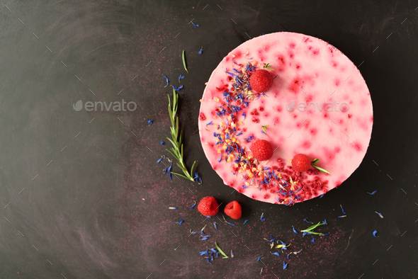 Delicious raspberry cake with fresh berries, rosemary and dry flowers on dark vintage background - Stock Photo - Images