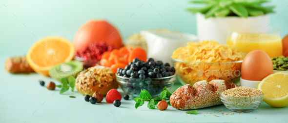 Corn flakes with milk, fresh berries, yogurt, boiled egg, nuts, fruits, orange, banana, peach for - Stock Photo - Images