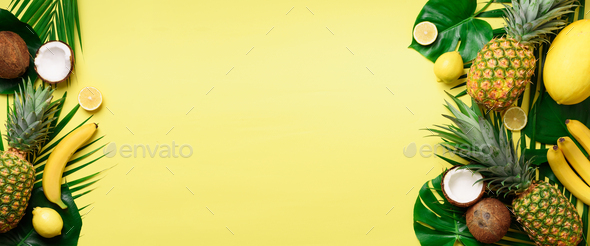 Exotic pineapples, ripe coconuts, banana, melon, lemon, tropical palm and green monstera leaves on - Stock Photo - Images