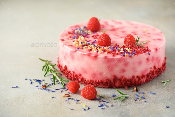 Delicious raspberry cake with fresh berries, rosemary and dry flowers on gray concrete background - Stock Photo - Images