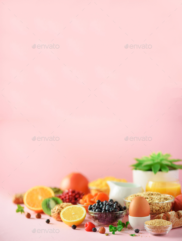 Breakfast served with soft boiled egg, oat flakes, nuts, fruits, berries, milk, yogurt, orange - Stock Photo - Images