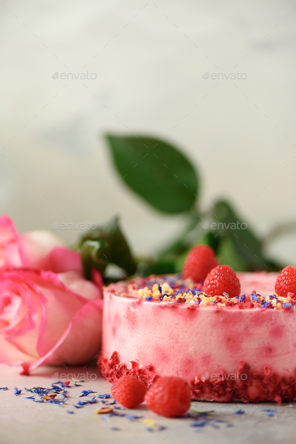 Pink roses and raspberry cake with fresh berries, rosemary, dry flowers on concrete background. Copy - Stock Photo - Images