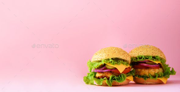 Fast food banner. Juicy meat burger with beef, cheese, lettuce, onion,  tomatoes on pink background Stock Photo by jchizhe
