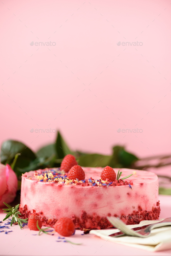 Delicious raspberry cake with fresh berries, rosemary and dry flowers on pink background. Copy space - Stock Photo - Images