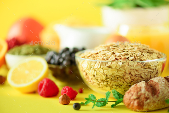 Oat flakes with milk, fresh berries, yogurt, boiled egg, nuts, fruits, orange, banana, peach for - Stock Photo - Images