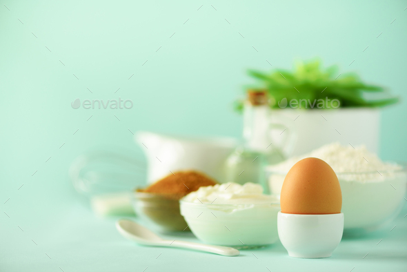White cooking utensils on blue background. Food ingredients. Macro of egg. Cooking cakes and baking - Stock Photo - Images