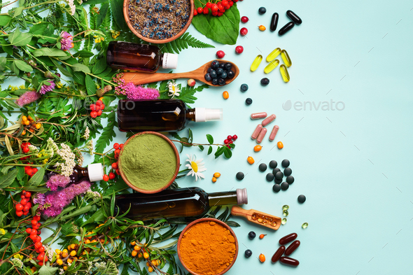 Alternative medicine. Holistic approach. Healing herbs and flowers over blue background. Top view - Stock Photo - Images