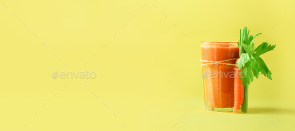 Fresh organic carrot juice with carrots, celery on yellow background. Vegetable smothie in glass - Stock Photo - Images