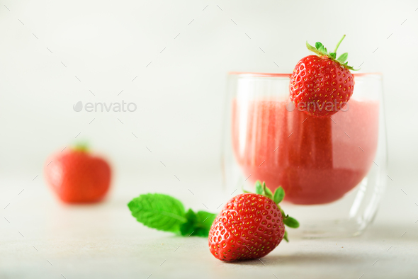 Red strawberry milkshake in glass on grey background with copy space. Summer food concept, vegan - Stock Photo - Images