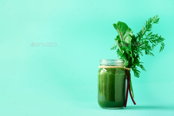 Smoothie with beet greens and carrot tops on blue background, copy space. Summer vegan food concept - Stock Photo - Images