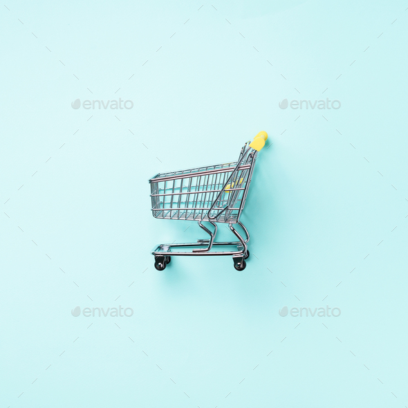 Shopping cart on blue background. Minimalism style. Square crop. Creative design. Top view with copy - Stock Photo - Images