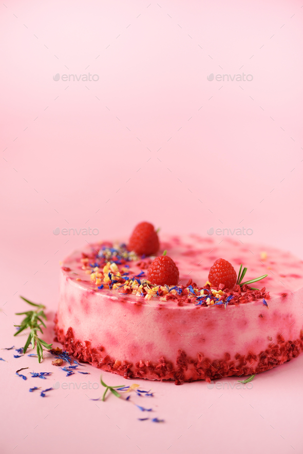 Delicious raspberry cake with fresh berries, rosemary and dry flowers on pink background. Copy space - Stock Photo - Images