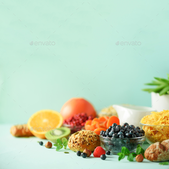 Healthy breakfast ingredients. Square crop. Oat and corn flakes, eggs, nuts, fruits, berries, toast - Stock Photo - Images