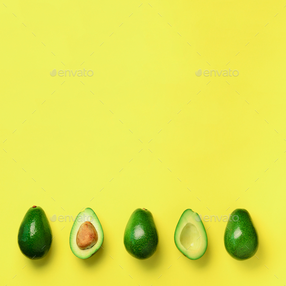 Organic avocado with seed, avocado halves and whole fruits on yellow background. Top view. Square - Stock Photo - Images