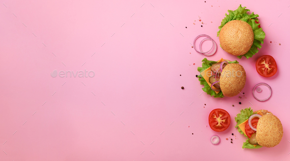 Fast food, unhealthy diet concept. Juicy homemade burgers, tomatoes, cheese, onion, cucumber and - Stock Photo - Images