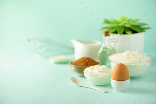 Time to bake. Baking ingredients - butter, sugar, flour, eggs, oil, spoon, brush, whisk, milk over - Stock Photo - Images