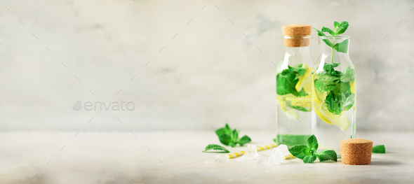 Detox water with mint, lemon and tropical monstera leaves on grey background. Banner with copy space - Stock Photo - Images
