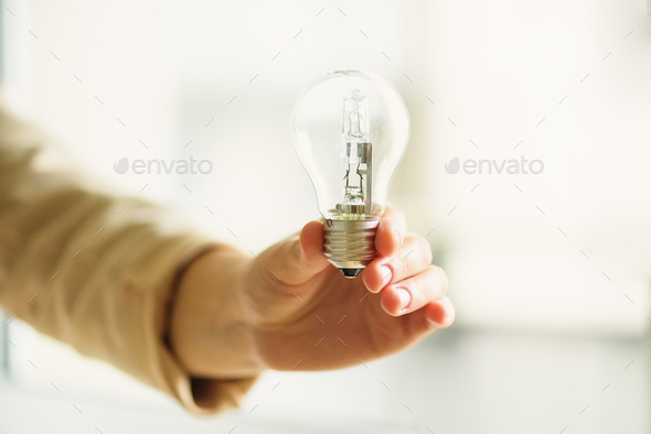 Woman hand holding light bulb on cream background with copy space. Creative idea, new business plan - Stock Photo - Images