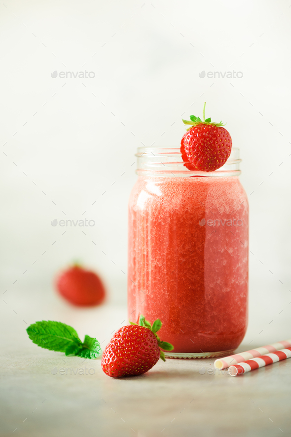 Red strawberry milkshake in glass jar on grey background with copy space. Summer food concept, vegan - Stock Photo - Images
