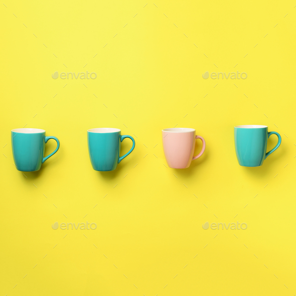Pattern from blue and pink cups over yellow background. Square crop. Birthday party celebration - Stock Photo - Images