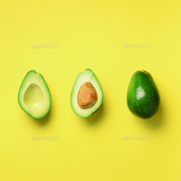 Organic avocado with seed, avocado halves and whole fruits on yellow background. Top view. Square - Stock Photo - Images
