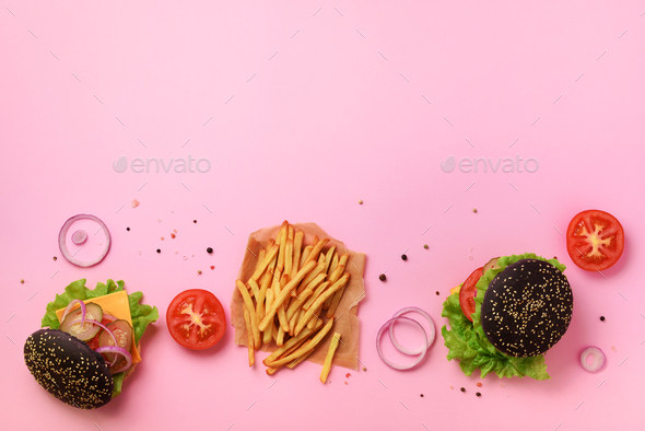 Black burger, french fries potatoes, tomatoes, cheese, onion, cucumber and lettuce on pink - Stock Photo - Images
